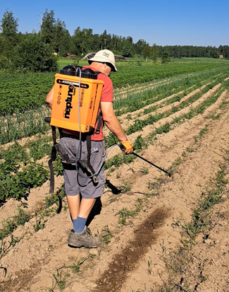 Kompostiuutteen levitys reppuruiskulla pellolle.